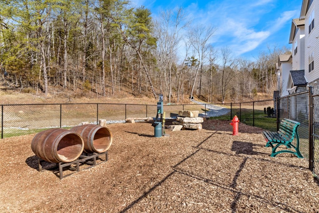 Ashland Farms Community Fenced-In Bark Park with Seating, Play Barrels, and Shade.
