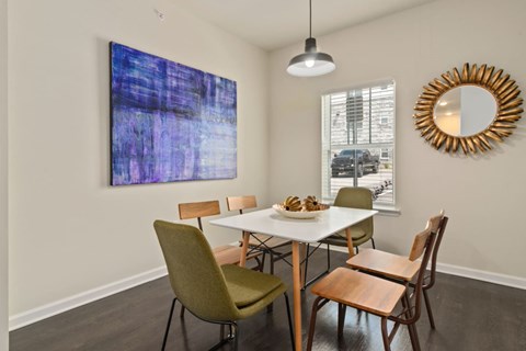 Dog-Friendly Apartments in Ashland City, TN - Ashland Farms - Dining Room with Wood-Inspired Plank Flooring, Table and Six Chairs, Mounted Wall Art, Sun-Framed Gold Mirror, Window, and Hanging Light Fixture.