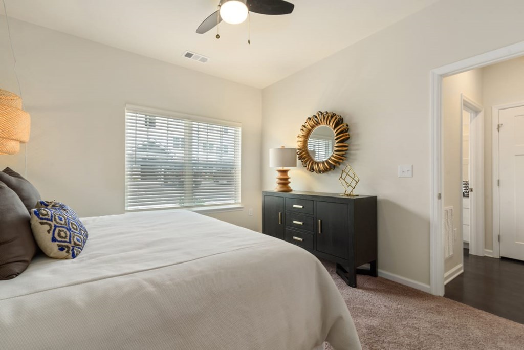 Apartments In Ashland City - Ashland Farms - Bedroom With Plush Carpeting, Bed, Large Window, and Ceiling Fan