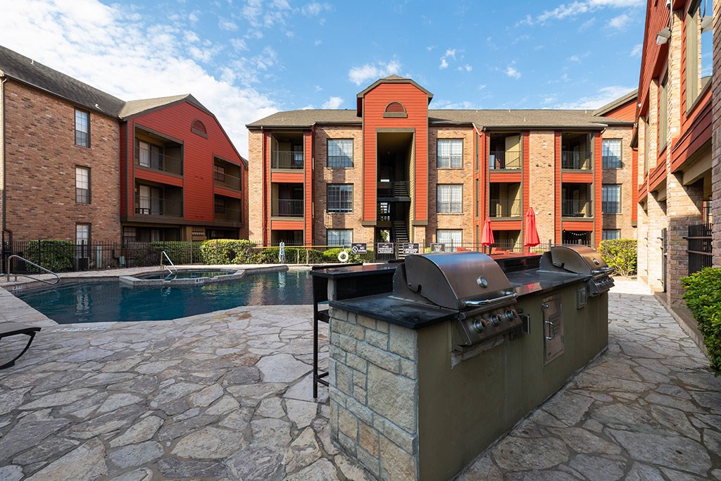 a patio with a grill and a swimming pool