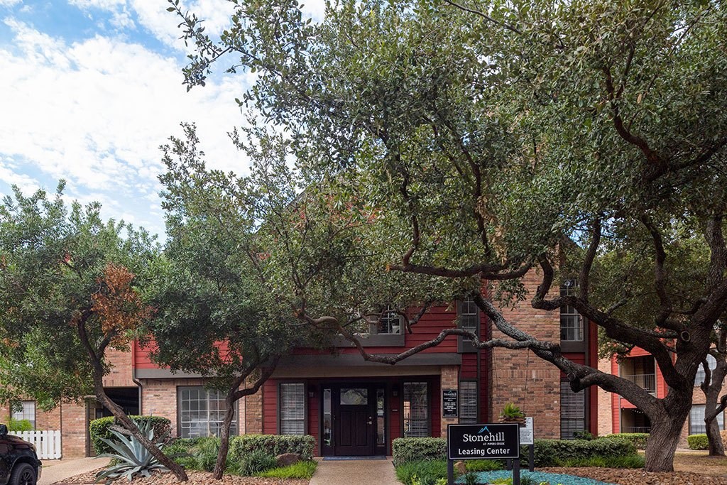 a building with trees and a sign in front of it