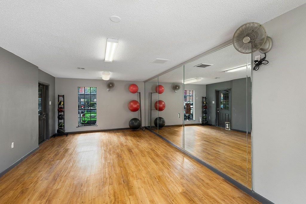 a dance room with mirrors and a wood floor