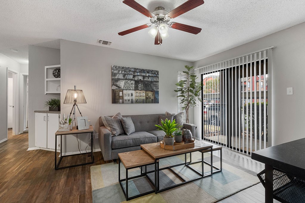 a living room with a couch and a ceiling fan
