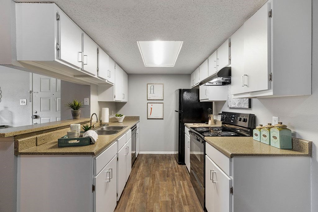 a kitchen with white cabinets and a black stove
