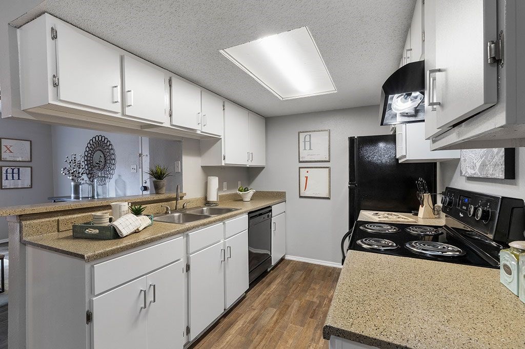 a kitchen with white cabinets and a black stove