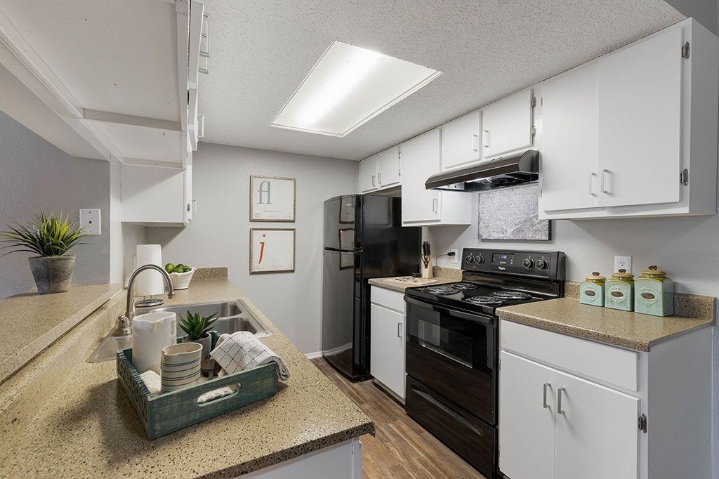 a kitchen with white cabinets and black appliances