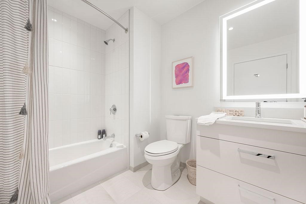 Bathroom with backlit mirror vanity and soaking tub