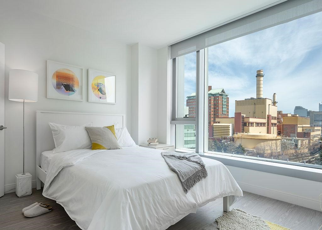 Bedroom with oversized window and city views