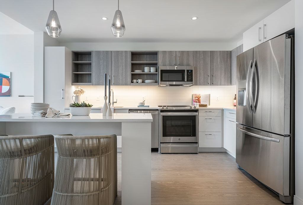 Kitchen with stainless steel appliances, two-tone kitchen cabinets and island a