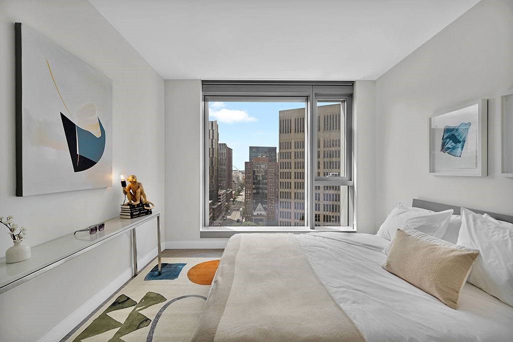 Bedroom with oversized window and city views