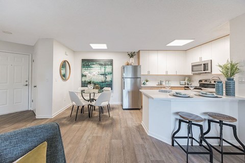 A kitchen with a white table and chairs.