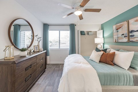 A bedroom with a bed, dresser, and mirror.