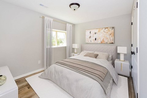 A bedroom with a large bed and a painting on the wall.