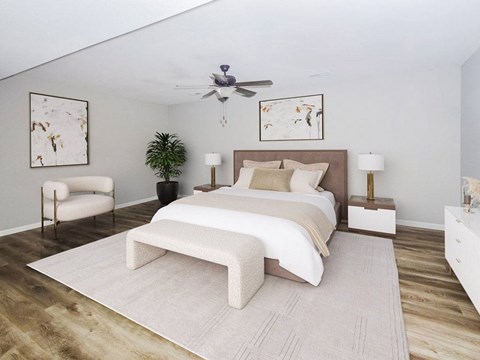 A bedroom with a large bed and a ceiling fan.