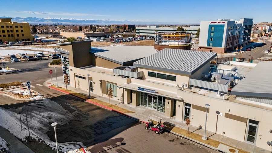a view from the top of a building of a parking lot and the mountains in the background