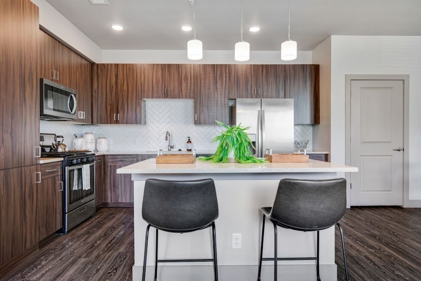 a kitchen with a large island with two stools in front of it