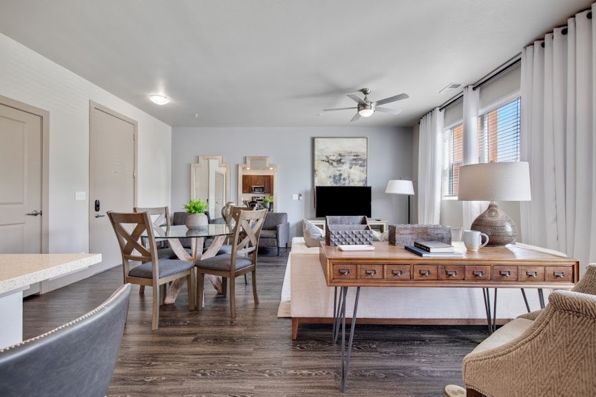 a living and dining area with a table and chairs and a ceiling fan