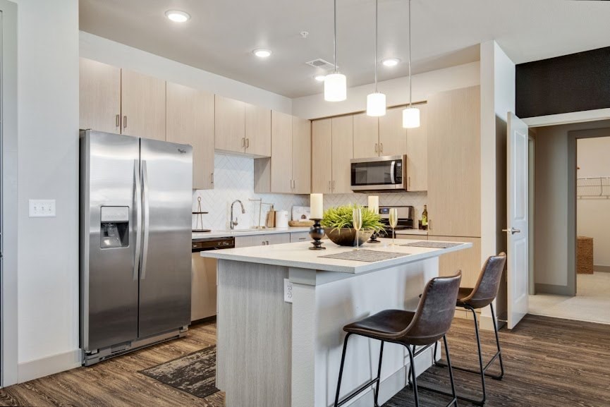 a kitchen with a large island and stainless steel appliances
