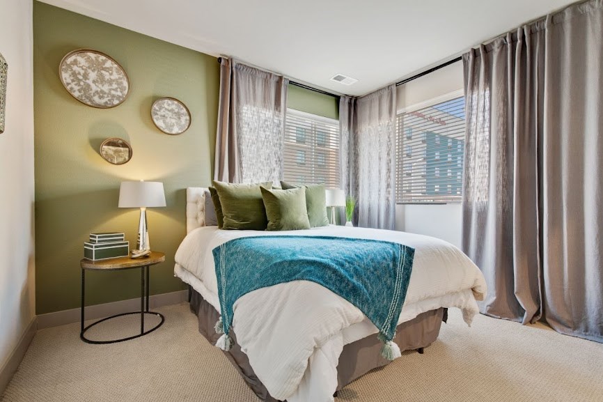 a bedroom with green walls and a white bed