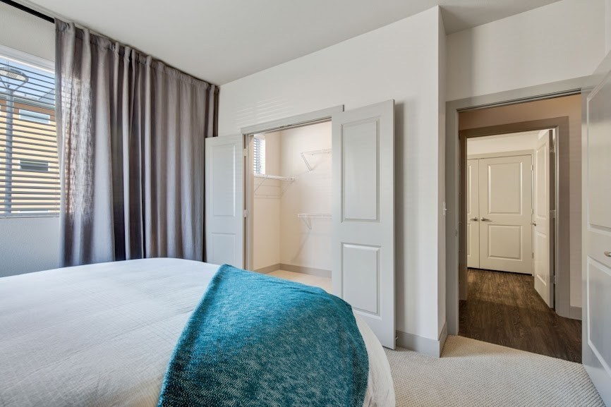 a bedroom with white walls and a blue blanket on the bed