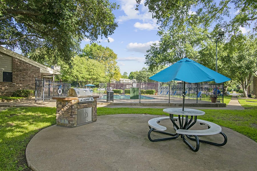 Picnic area with Grill and gated pool in the background