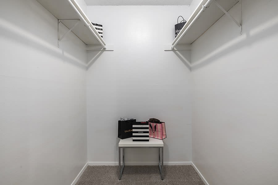 Walk in closet with small table and built in shelves