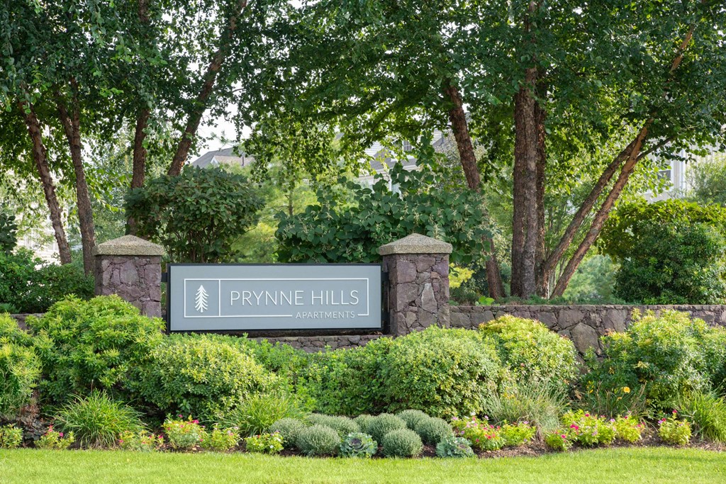 private hills sign in front of a stone wall and trees