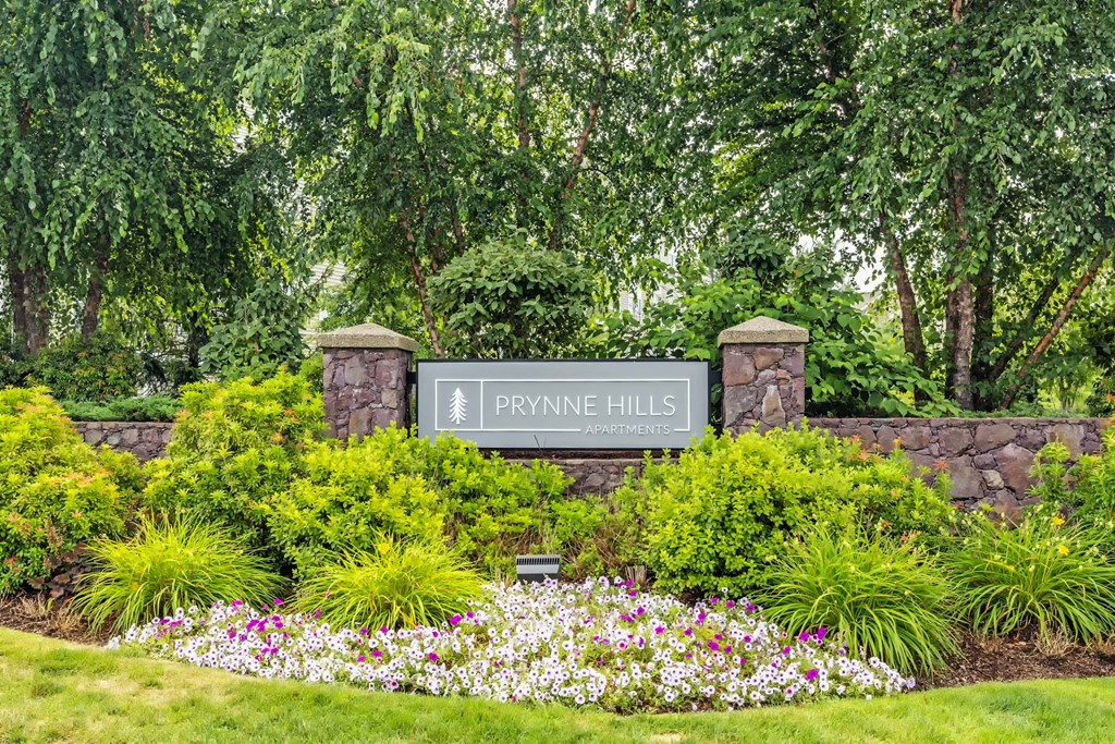 a park with flowers and a sign prining hills