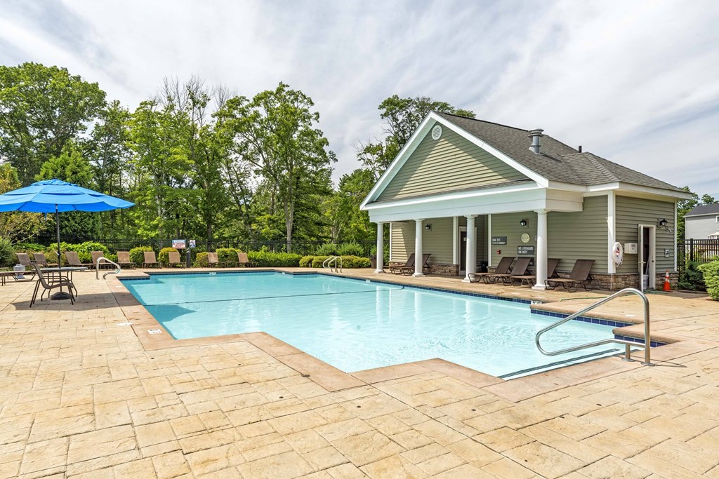 a swimming pool with a house in the background