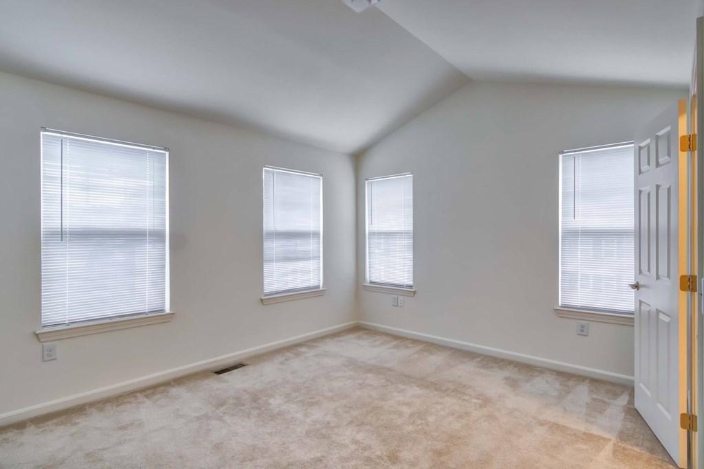 an empty room with three windows and a door