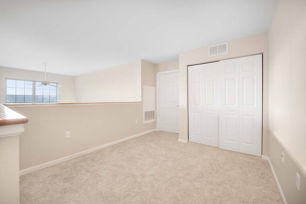 an empty bedroom with a closet and a door to the bathroom