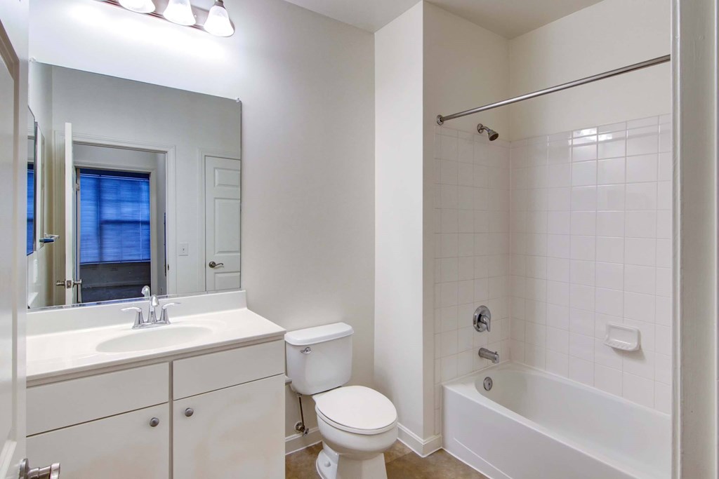 a bathroom with a toilet and a tub and a sink