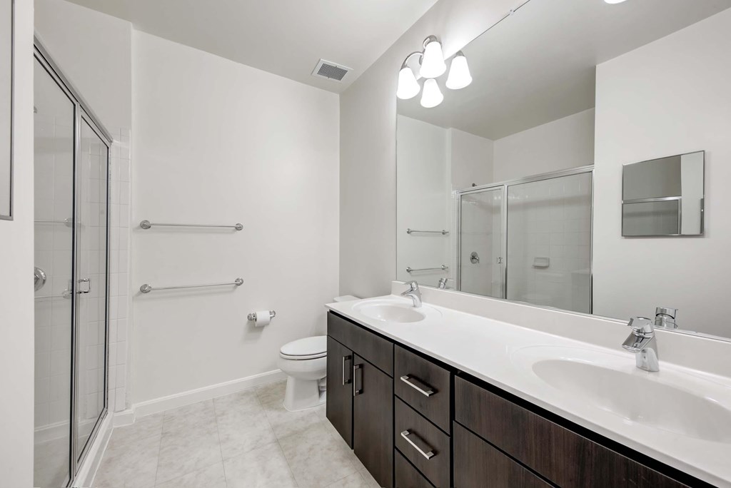 a bathroom with a large mirror and a sink and a shower