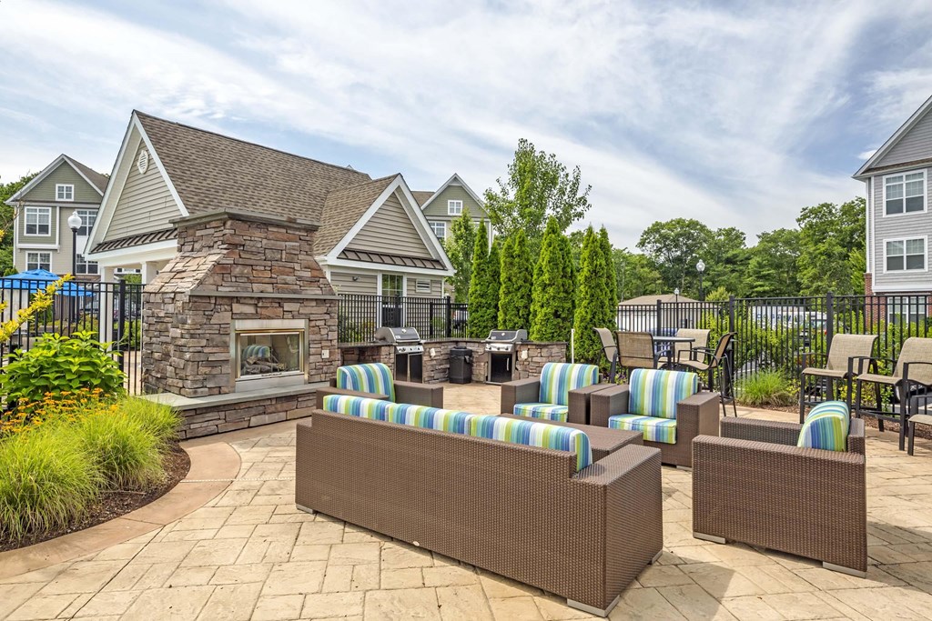 the clubhouse patio with chairs and tables and a stone fireplace