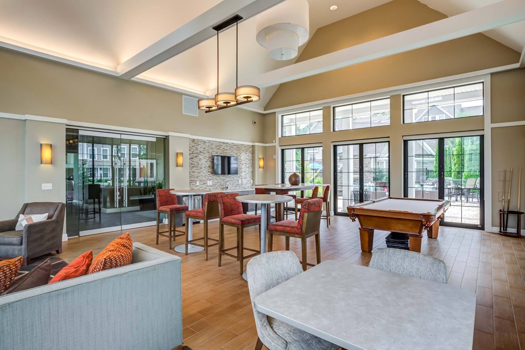 a clubhouse with a pool table and tables