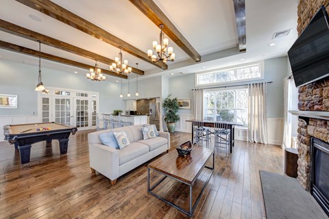 A living room with a pool table and a fireplace.