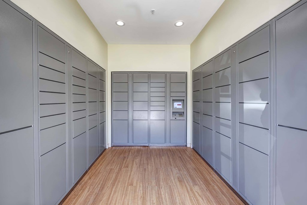 a long hallway with gray lockers and a wood floor