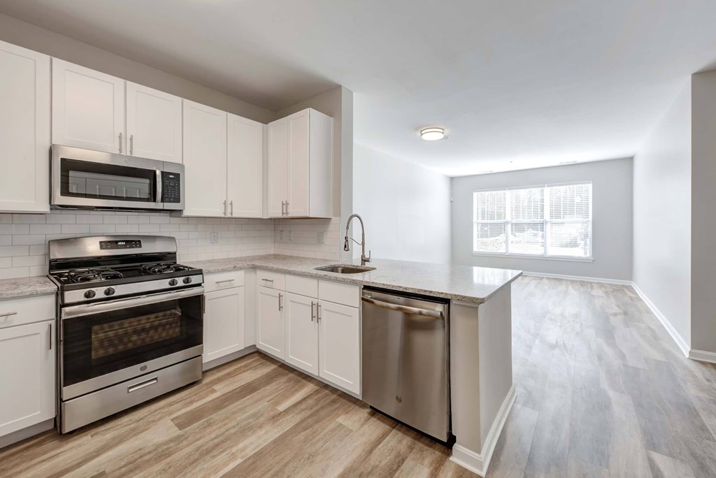 a kitchen with white cabinets and stainless steel appliances