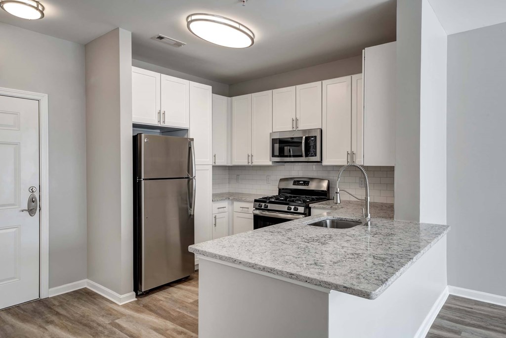 a kitchen with a granite counter top and a stainless steel refrigerator