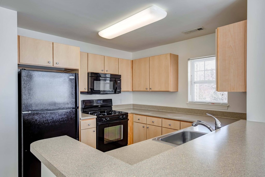 a kitchen with a counter top and a black refrigerator