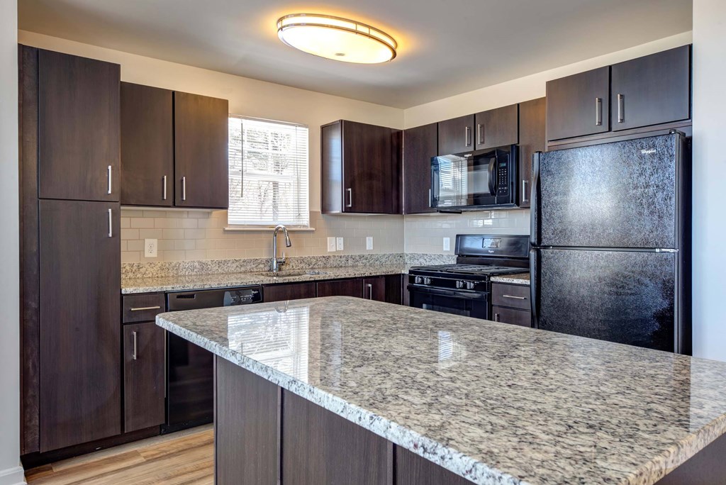a kitchen with granite counter tops and wooden cabinets