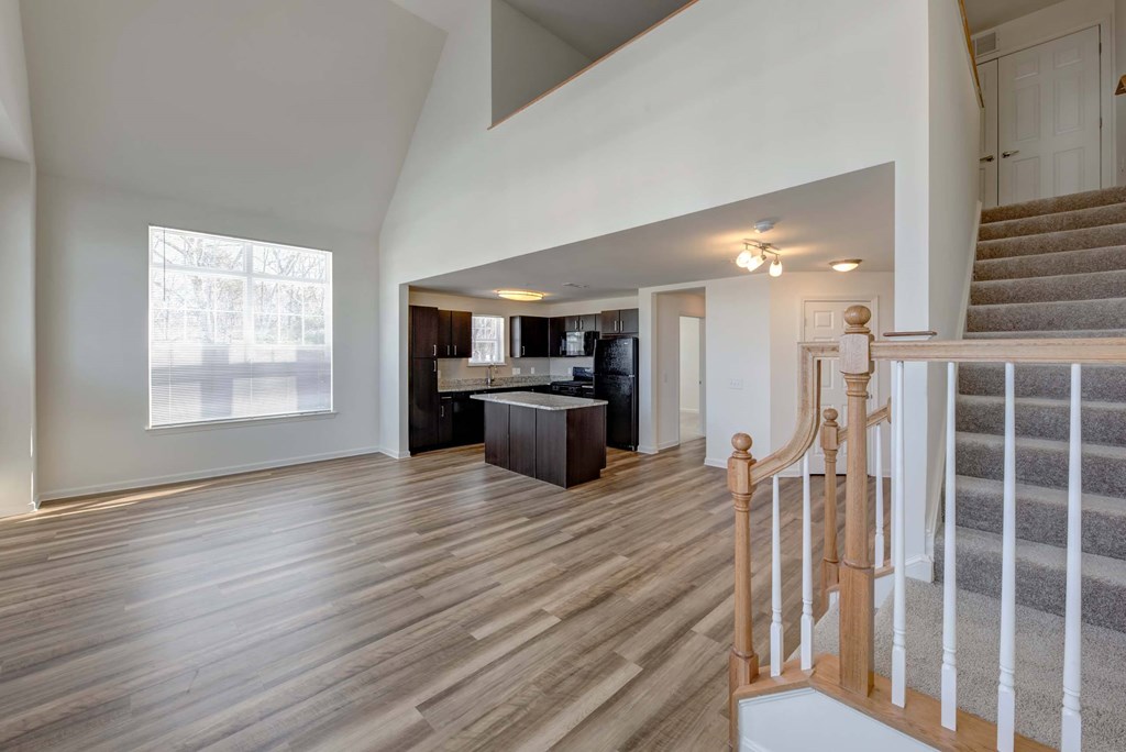 a view of a living room and a kitchen from the stairs