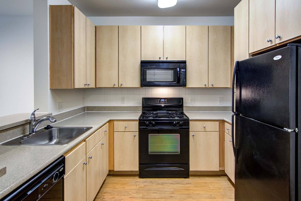 a kitchen with black appliances and wooden cabinets