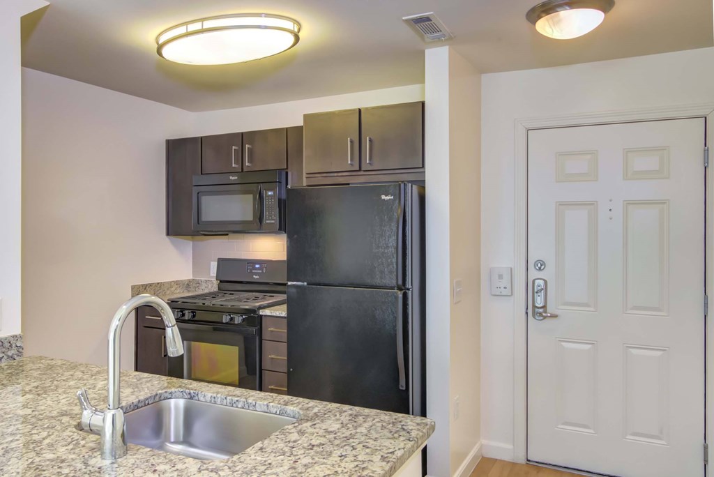 a kitchen with black appliances and granite counter tops