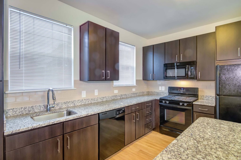 a kitchen with wooden cabinets and granite counter tops