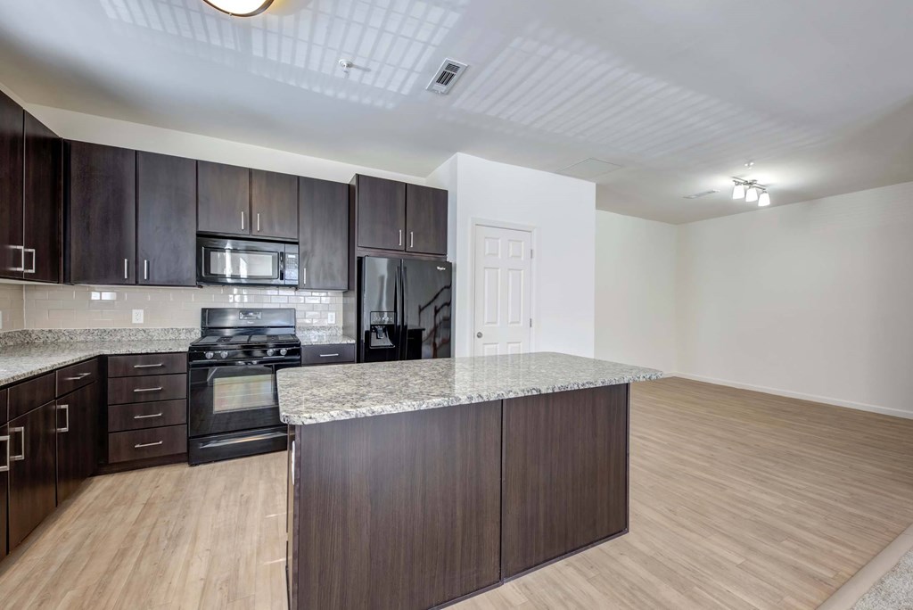 a kitchen with wooden cabinets and a marble counter top