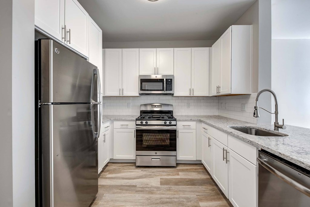a kitchen with white cabinets and stainless steel appliances