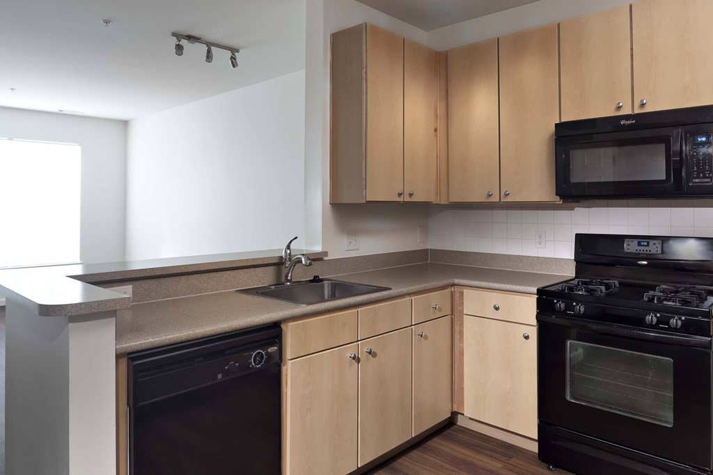 a kitchen with black appliances and wooden cabinets