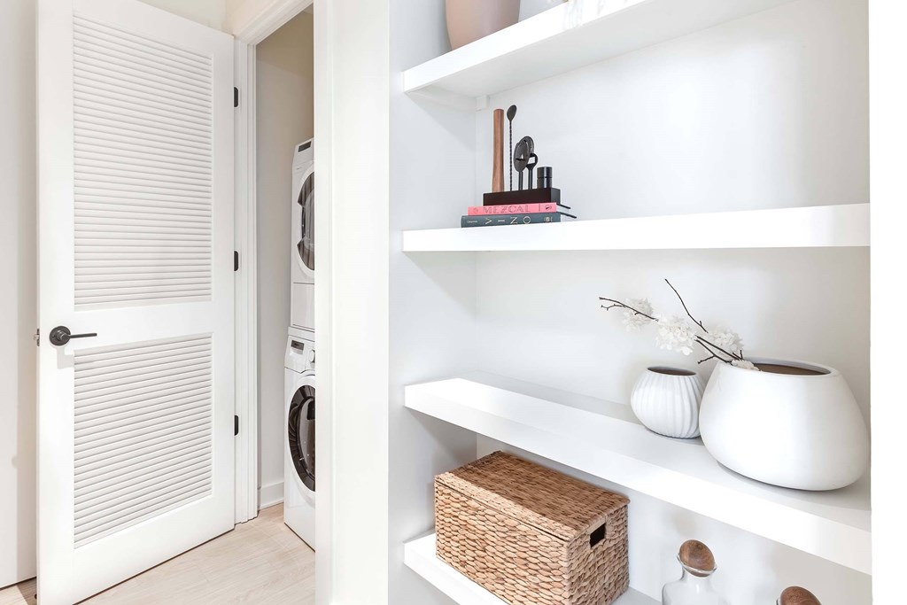 a white laundry room with white appliances and white shelves
