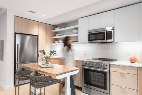 a kitchen with white cabinets and a wooden table